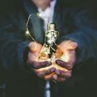 Man håller i en glödlampa. Foto: Riccardo Annandale / Unsplash